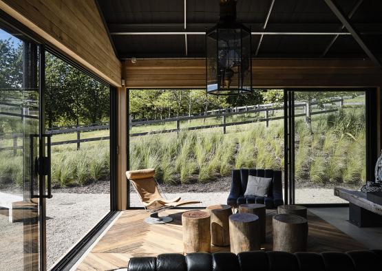 a room with a large glass wall and a chair and a table