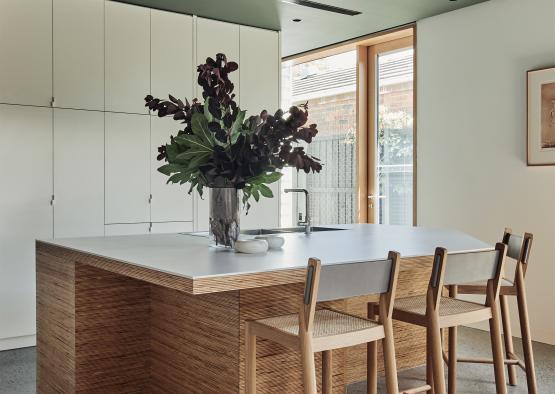 a table with chairs and a vase of flowers