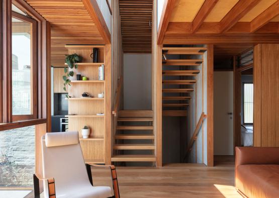 a room with wood stairs and a chair