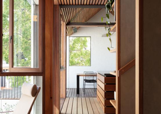 a room with a wood ceiling and a white chair