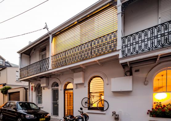 a building with a balcony and a car parked on the side of it