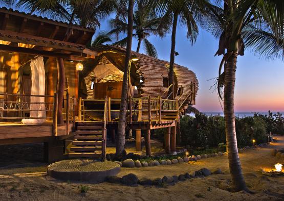 a building with a deck and palm trees