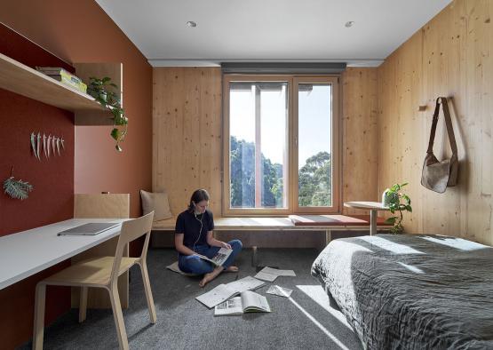 a woman sitting on the floor in a bedroom