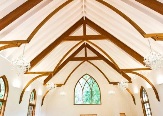 a church with wooden benches and chandeliers