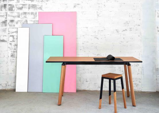 a table and stools in front of a white wall