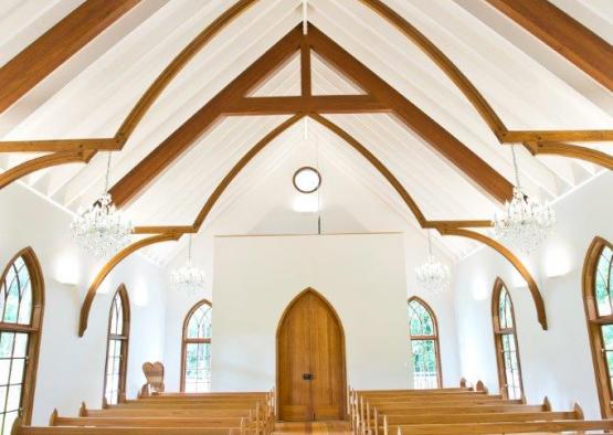 a church with wooden benches and a chandelier