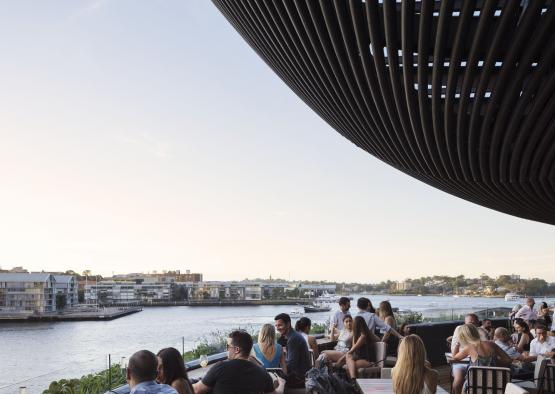 a group of people sitting at tables outside