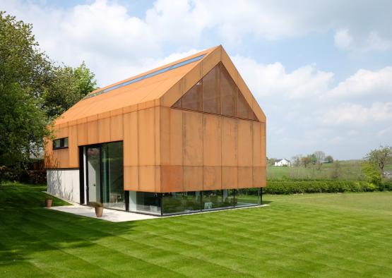 a building with a glass roof and a green lawn