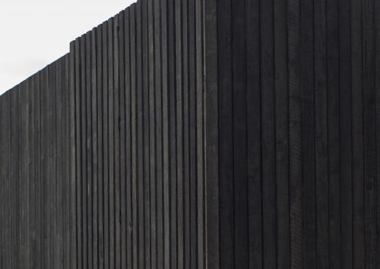 a black rectangular building with a white sky