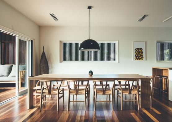 a dining table with chairs in a room with windows