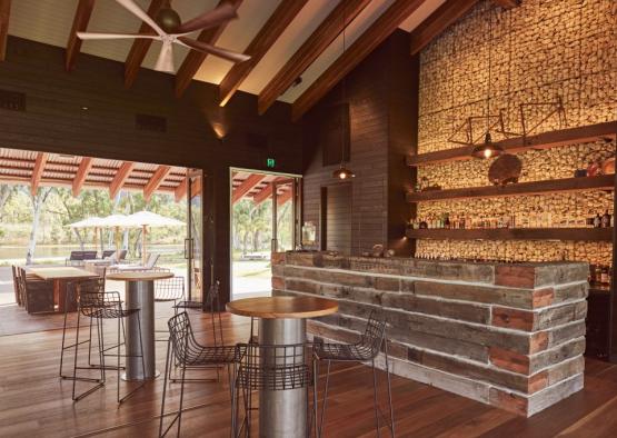 a bar with a wood wall and a table and chairs