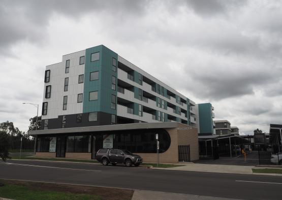 a building with a parking lot and a car parked on the side of the road