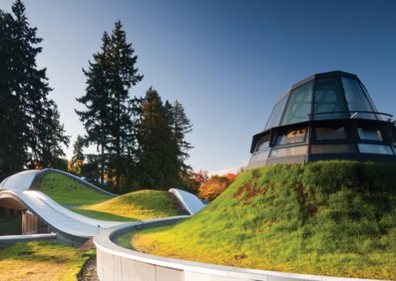 a building on a hill with grass and trees