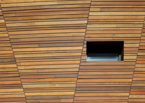 a wood paneled wall with a square window