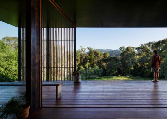 a wooden deck with a view of trees and mountains