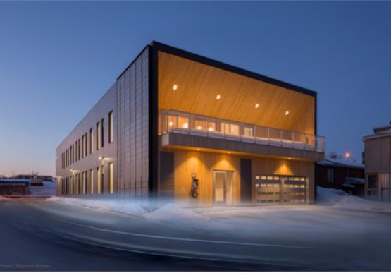 a building with a garage and a car in the snow