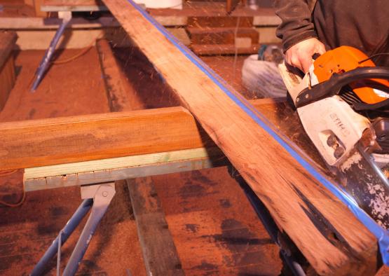 a person using a saw to cut a piece of wood