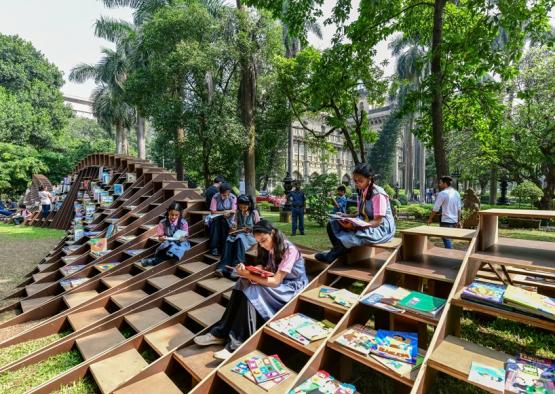 a group of people sitting on stairs with books on them