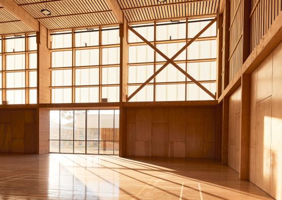 a large room with windows and a wooden ceiling