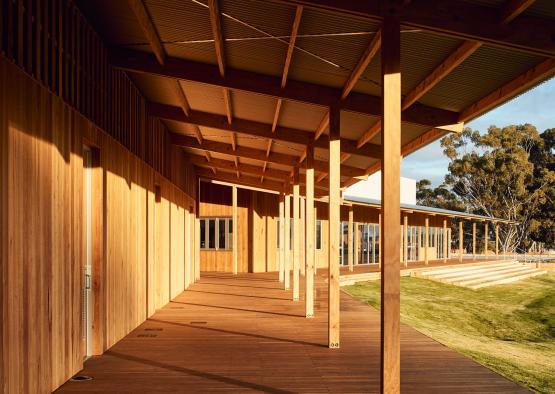 a wooden building with a porch and a lawn