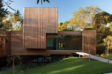 a wood house with a walkway and grass