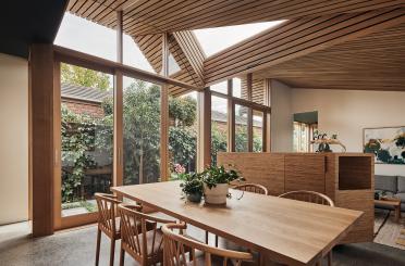 a dining table with chairs and a large skylight