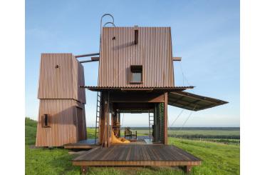 a wooden structure in a grassy field