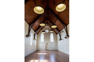 a room with a wood floor and ceiling with lights