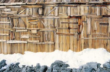 a wooden building with snow on the ground